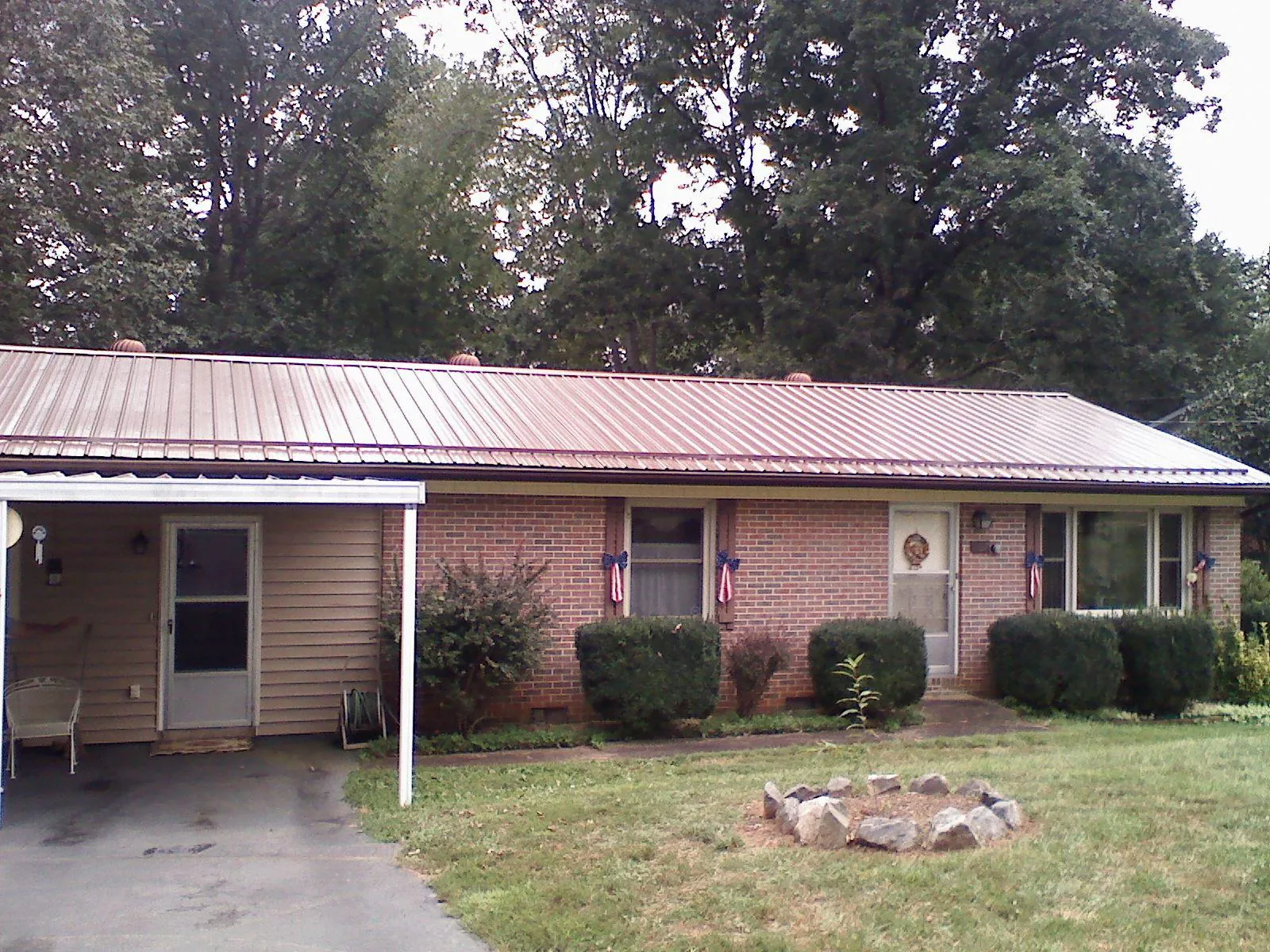 Bronze metal roof and carport on a brick ranch home — Roof Repair work by our crew in Stockport